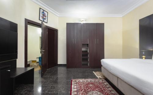 a bedroom with a large bed and a closet at ROYALE CROWN VILLA in Abuja