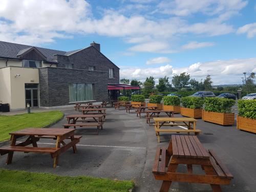 a row of wooden benches in front of a building at Kettles Country House Hotel in Swords