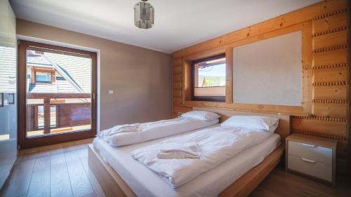 Un dormitorio con una cama grande con espejo. en Mocarni, Sun & Snow, en Kościelisko