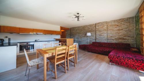 Una cocina y una sala de estar con una mesa y un sofá. en Mocarni, Sun & Snow, en Kościelisko