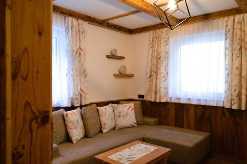 a living room with a couch and a window at Ferienwohnung Rohrmoser mit 2 Schlafzimmern in Hüttschlag