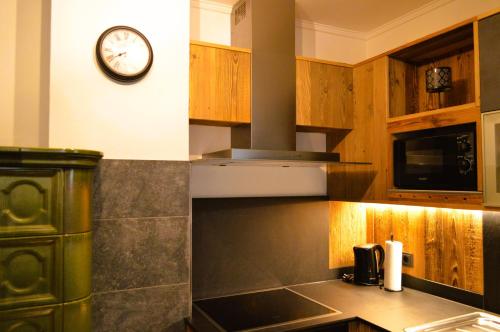 a kitchen with a clock on the wall and a stove at Ferienwohnung Rohrmoser mit 2 Schlafzimmern in Hüttschlag