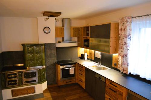 a kitchen with a sink and a stove top oven at Ferienwohnung Rohrmoser mit 2 Schlafzimmern in Hüttschlag