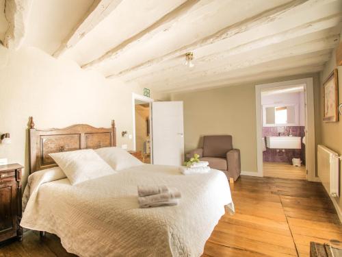 una camera da letto con un letto e una sedia in una stanza di Preciosa casa para familias y grupos en Navarra a Añorbe