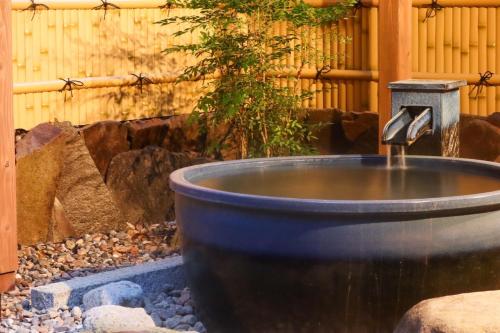 a water fountain in the middle of a garden at Furusato in Takayama