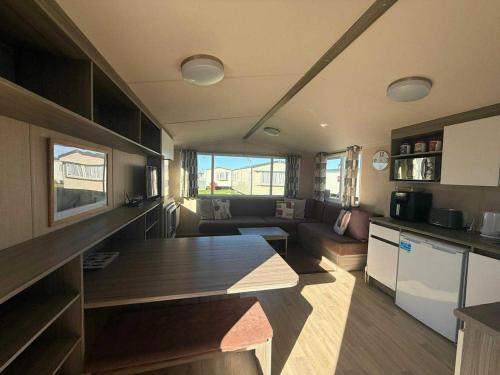 a kitchen and living room with a table and a couch at Salty Breezes in Ingoldmells