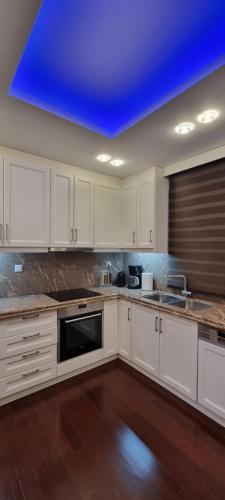 a kitchen with white cabinets and a blue ceiling at Place 2 Be in Nafpaktos