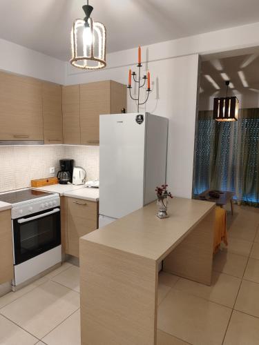 a kitchen with a white refrigerator and a table at Δροσιά in Nafplio
