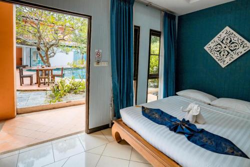 a bedroom with a bed and a sliding glass door at Kasalong Resort and Spa Pattaya in Pattaya Central