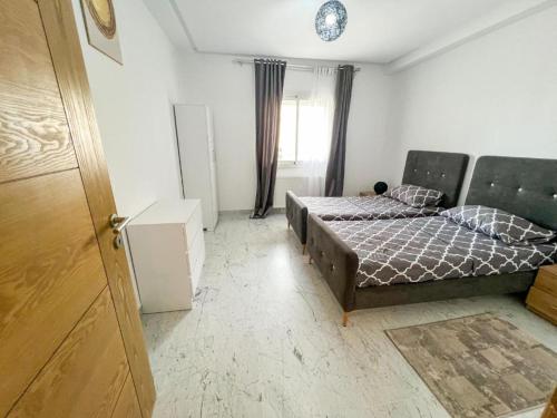 a small bedroom with two beds and a window at Amazing 2BR Apartment in Tunis in Tunis