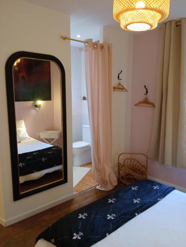 a bedroom with a mirror and a bed and a bathroom at la pomme d'amour in Sully-sur-Loire