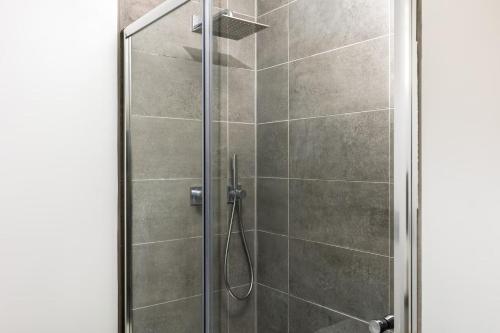 a shower with a glass door in a bathroom at Pass the Keys Modern family home Garden Parking in Bourton on the Water