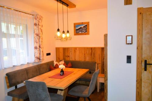 a dining room with a wooden table and chairs at Ferienwohnung Rohrmoser mit 1 Schlafzimmer in Hüttschlag