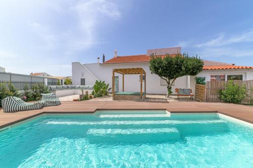 a swimming pool in front of a house at Esteva CountryHouse in Rogil