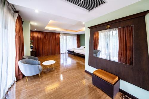 a living room with a television and a couch at Kasalong Resort and Spa Pattaya in Pattaya Central