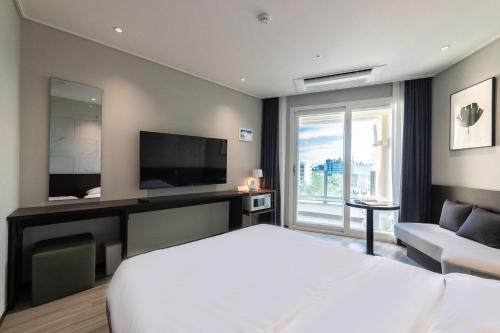 a hotel room with a bed and a television at 모어댄 속초해변점 in Sokcho