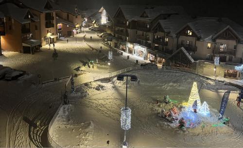 an indoor amusement park in the snow at night at L'Ourson skis aux pieds in Valmeinier