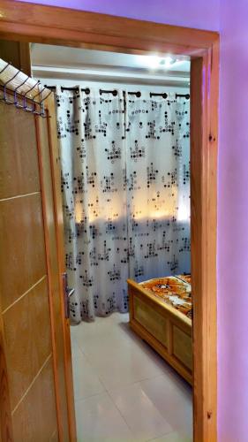 a room with a bed and a shower curtain with music at La Brise Saidia in Saïdia