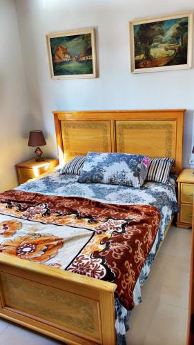 a bedroom with a large bed with a wooden headboard at La Brise Saidia in Saïdia