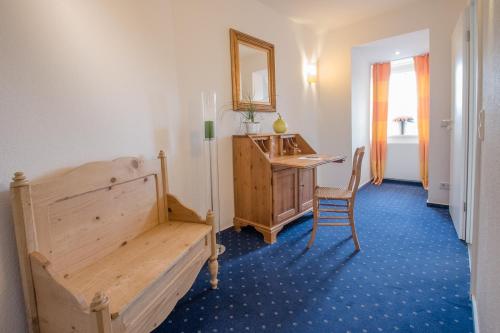 a bedroom with a bed and a desk and a mirror at Posthotel Monegro in Steinfurt