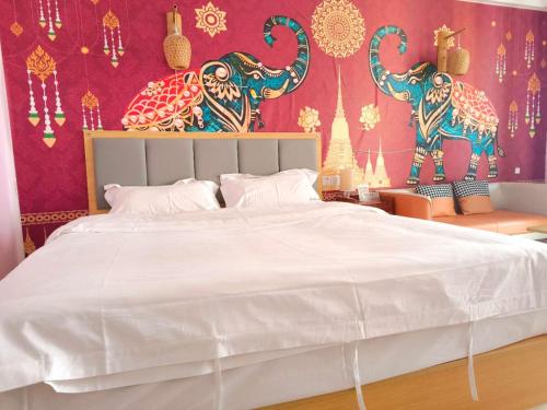 1 dormitorio con 1 cama blanca grande y pared roja en LanMei Holiday Hotel, en Ban Botèn