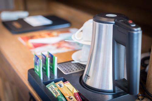 a counter with a coffee maker on a desk at Posthotel Monegro in Steinfurt
