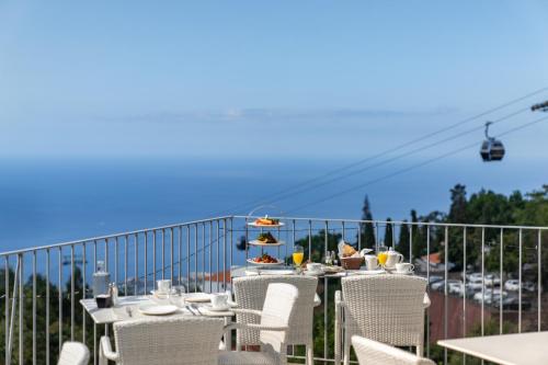 a table and chairs on a balcony with a ski lift at OurMadeira - Babosas Village, gardénias and greenspaces in Funchal