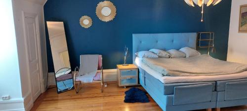 a blue bedroom with a bed and a blue wall at Stor lägenhet för familj eller företag in Norrköping