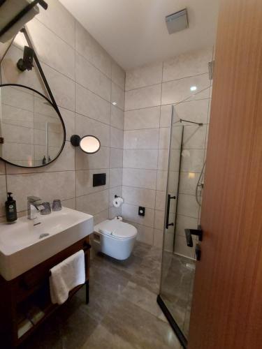 a bathroom with a sink and a shower and a toilet at Ramada by Wyndham Budapest City Center in Budapest