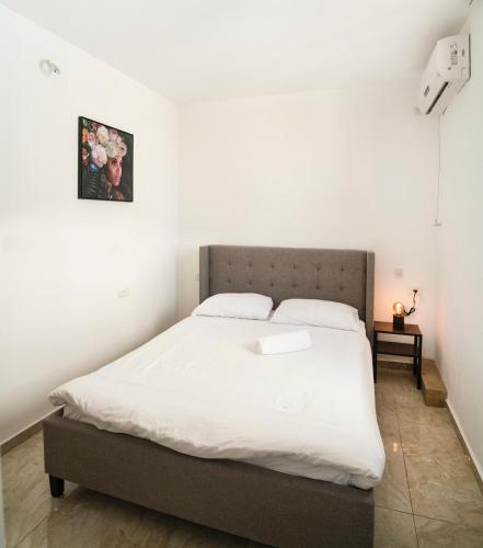 a bedroom with a large bed with white sheets at Sublet TLV 270 in Tel Aviv
