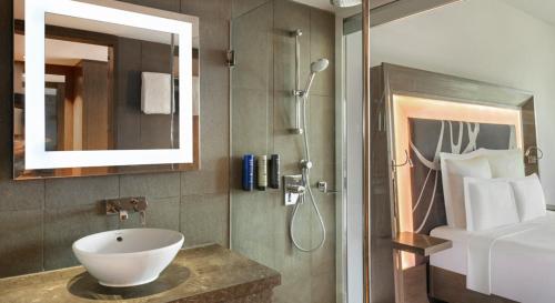 a bathroom with a sink and a shower at Novotel New Delhi Aerocity in New Delhi