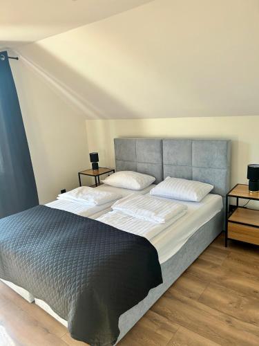 a bedroom with a large bed and two night stands at Pokoje Gościnne Dudziński in Leśna