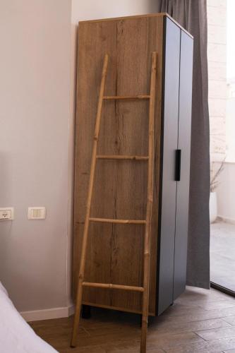 a wooden book shelf next to a refrigerator at Sublet TLV 270 in Tel Aviv