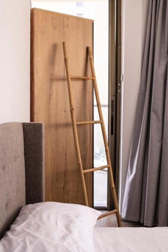 a wooden ladder next to a bed next to a door at Sublet TLV 270 in Tel Aviv
