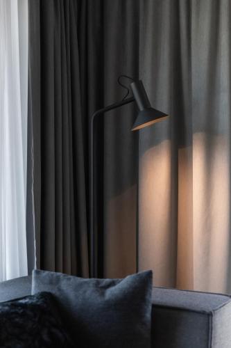 a black lamp sitting in front of a curtain at GOING TRIPLE A apartments WEST in Going