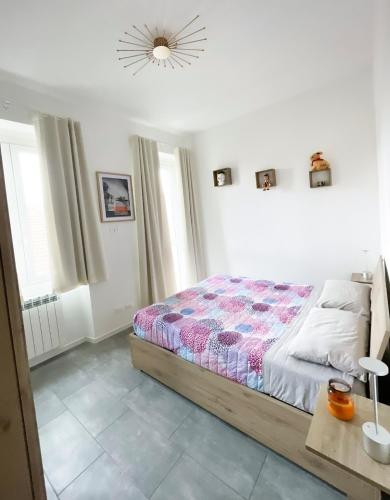 a white bedroom with a bed and a lamp at Evelina Malpensa & Busto centro in Busto Arsizio