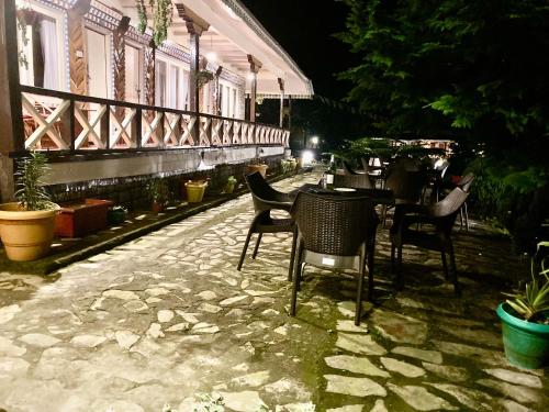 a group of chairs and tables on a patio at night at MayaTels - Maya Eco Huts, Pelling in Pelling