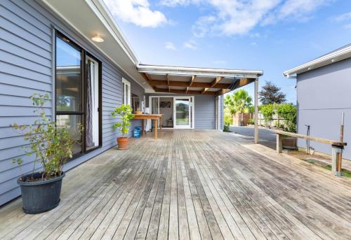 an outdoor deck with a table and benches on a house at Centre and Convenience Vacant Home in Pokeno