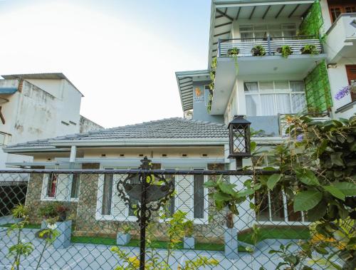 a house with a fence in front of it at K's Cove in Kandy
