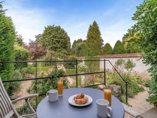 einen Tisch mit einem Teller Gebäck auf dem Balkon in der Unterkunft Kings Cottage North - Uk49855 in Broad Chalke