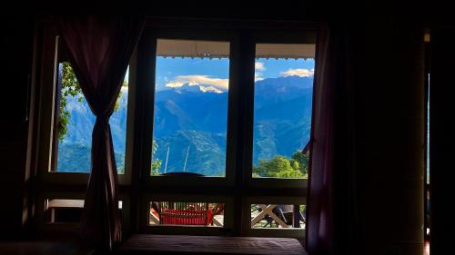 a window with a view of mountains at MayaTels - Maya Eco Huts, Pelling in Pelling