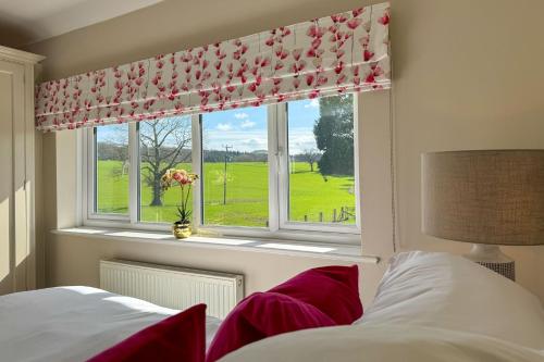 a bedroom with a window with a view of a golf course at Marrington Lodge in Chirbury