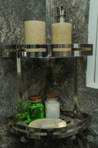 a metal shelf with three bottles and candles on it at K's Cove in Kandy