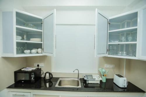 a kitchen with white cabinets and a sink at K's Cove in Kandy