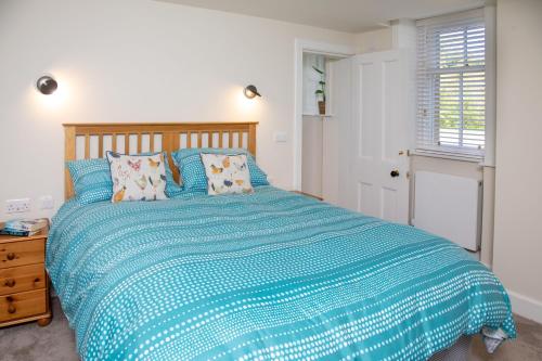a bedroom with a bed with a blue comforter at The Butler's Flat at Solsgirth Home Farm in Dollar