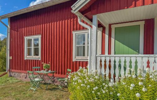 a red house with a table and chairs in front of it at 2 Bedroom Amazing Apartment In Flisby in Ägersryd