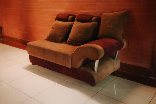 a brown couch sitting against a wall at Misty Night Wayanad Bamboo Resort in Wayanad