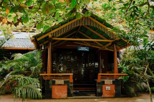 a small building with two benches in front of it at Misty Night Wayanad Bamboo Resort in Wayanad