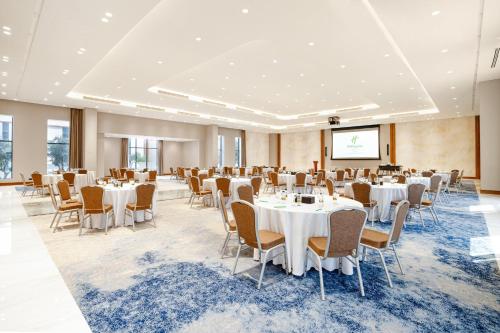 a conference room with tables and chairs and a projection screen at Holiday Inn Riyadh The Business District by IHG in Riyadh
