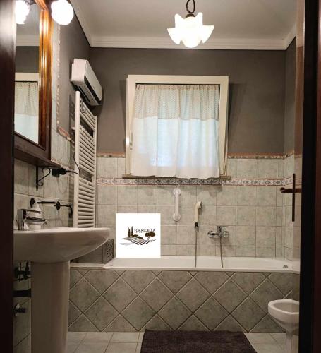 a bathroom with a bath tub and a sink at Torricella Hosting in Torricella